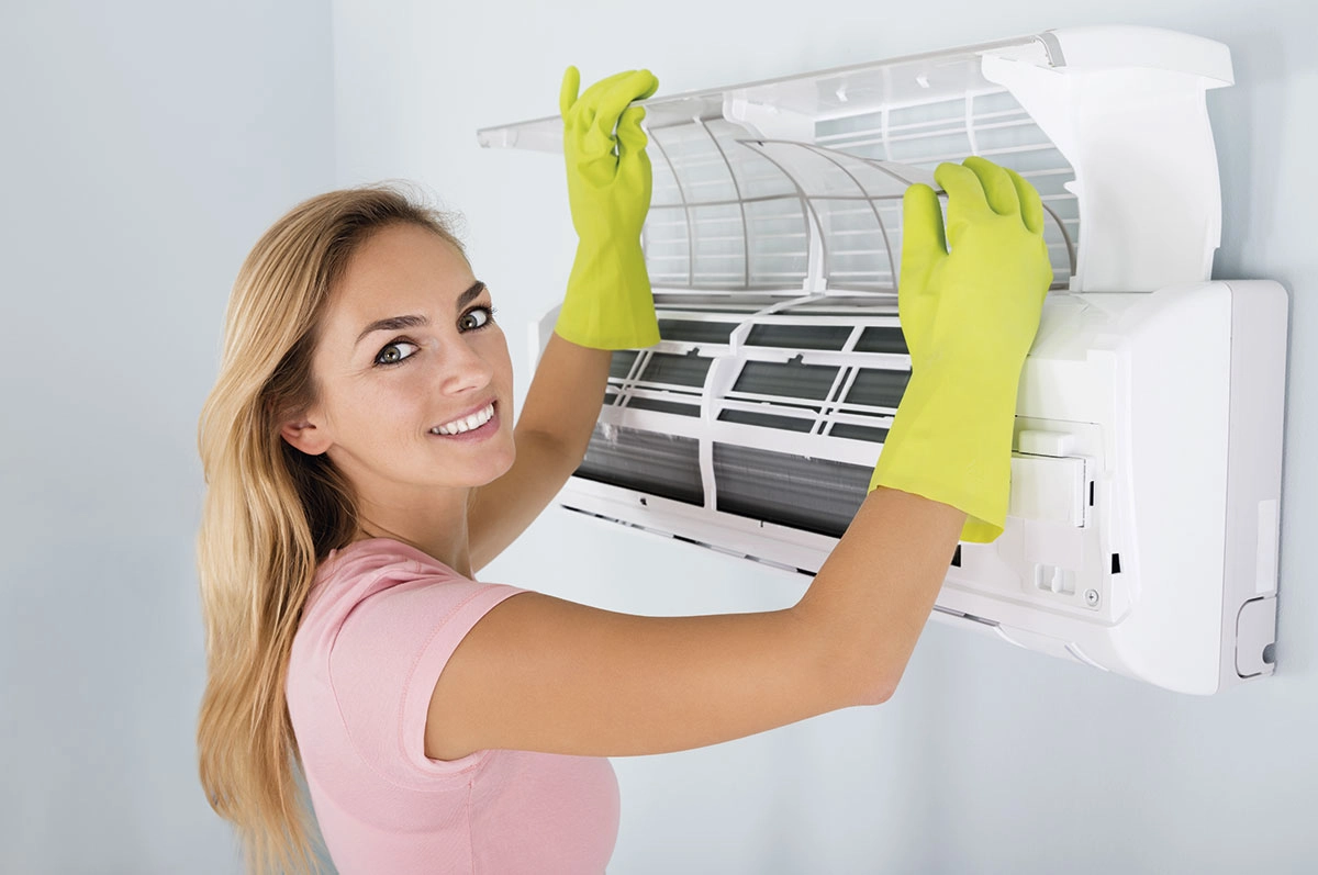 Persona limpiando filtros de aire acondicionado bajo agua